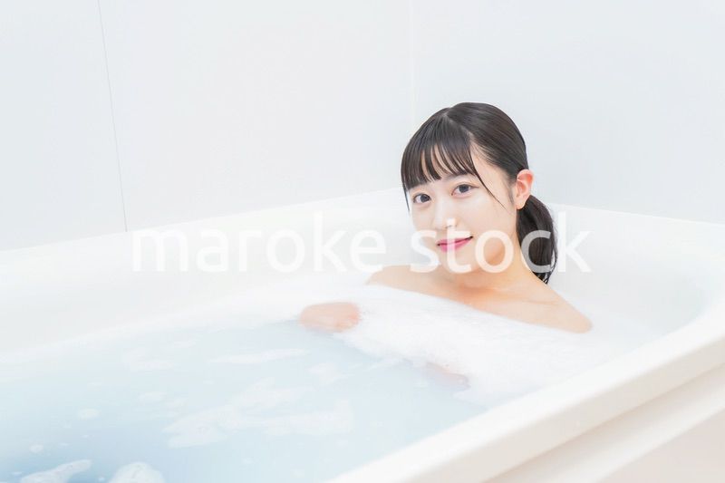 お風呂でお湯に浸かる若い女性