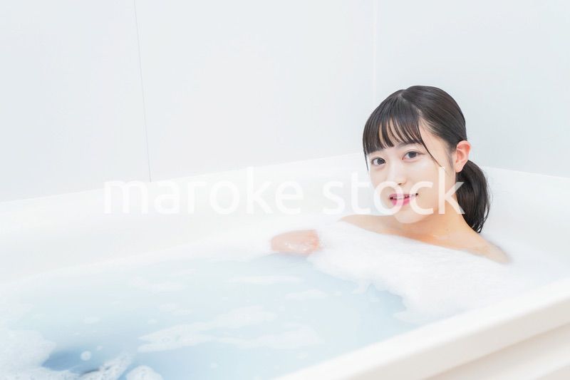お風呂でお湯に浸かる若い女性