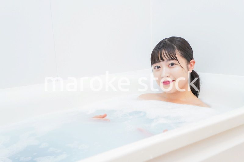 お風呂でお湯に浸かる若い女性