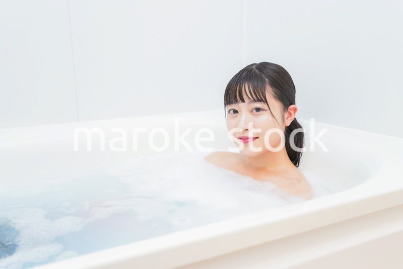 お風呂でお湯に浸かる若い女性