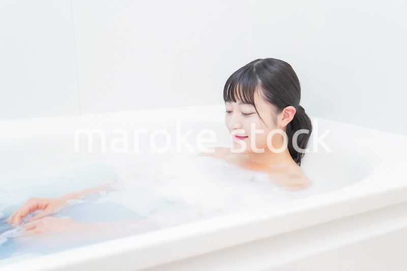 お風呂でお湯に浸かる若い女性