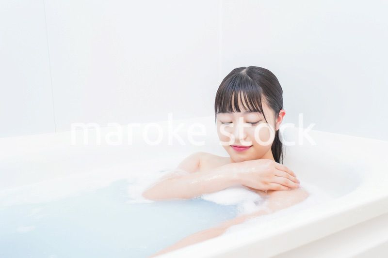 お風呂でお湯に浸かる若い女性