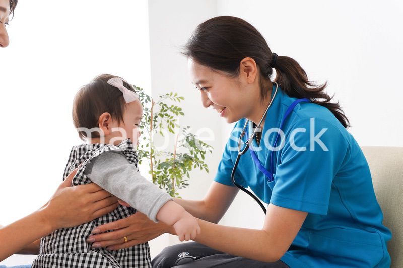 赤ちゃんの診察をする若いドクター