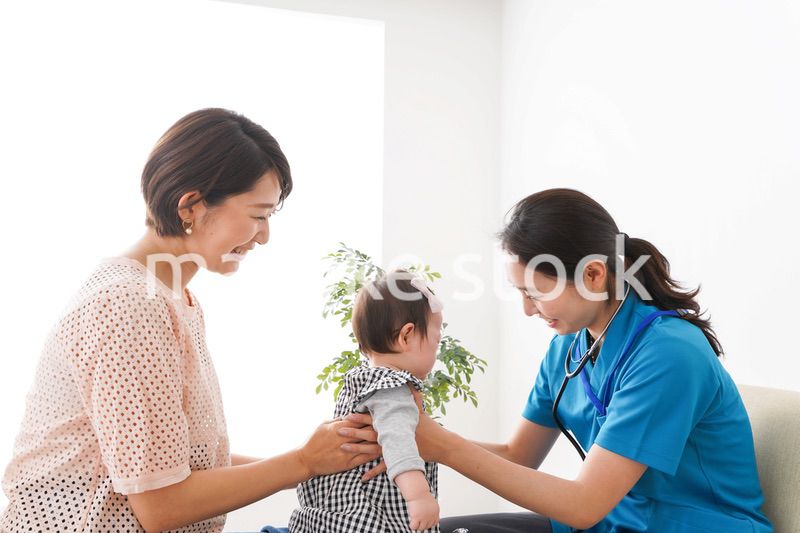 赤ちゃんの診察をする若いドクター