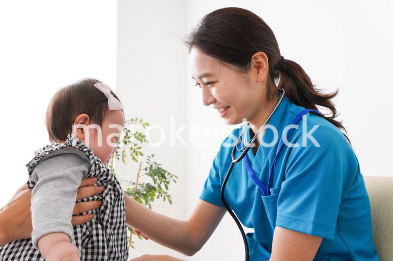 赤ちゃんの診察をする若いドクター