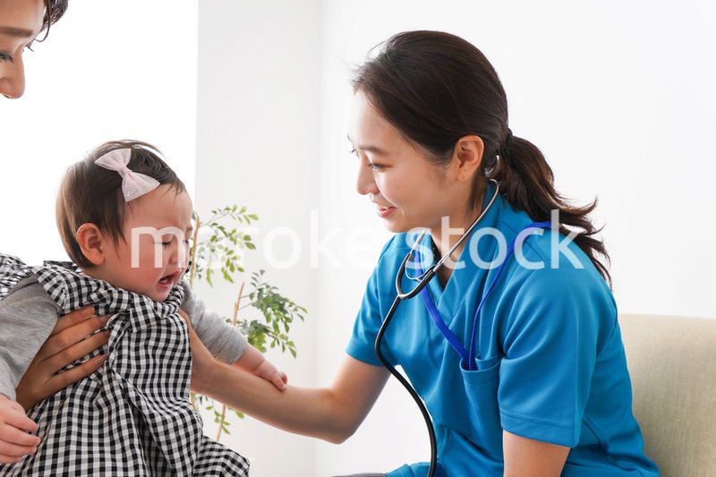 赤ちゃんの診察をする若いドクター