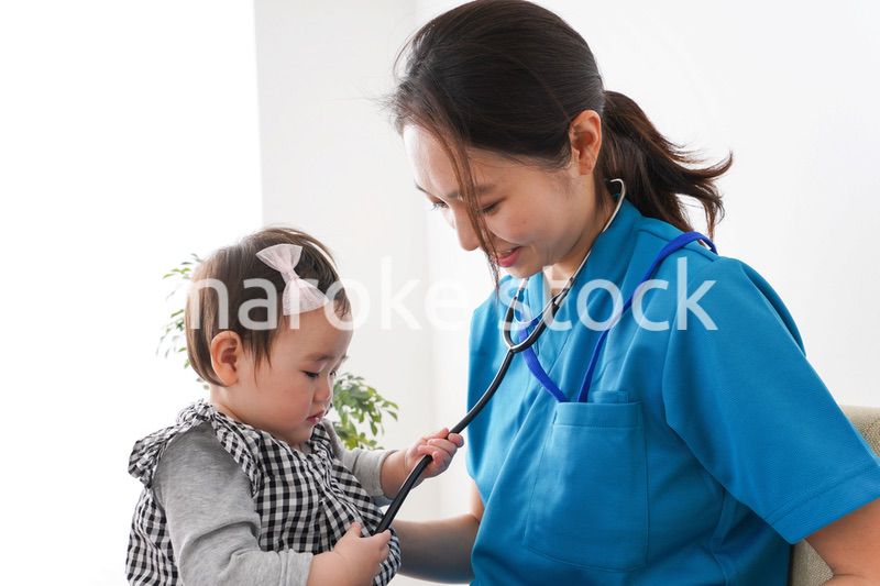 赤ちゃんの診察をする若いドクター