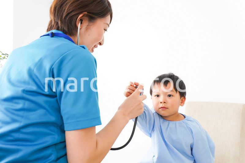 子どもを診察する若い看護師