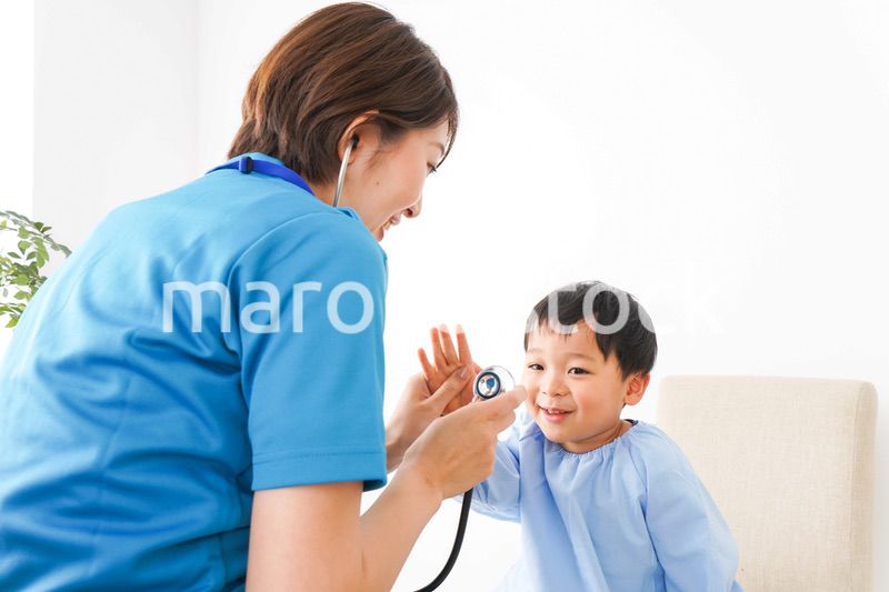 子どもを診察する若い看護師