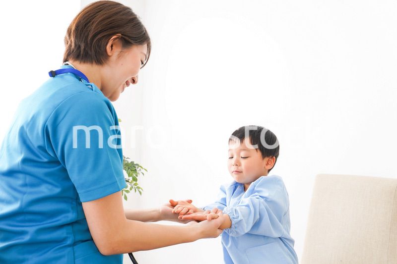 子どもを診察する若い看護師