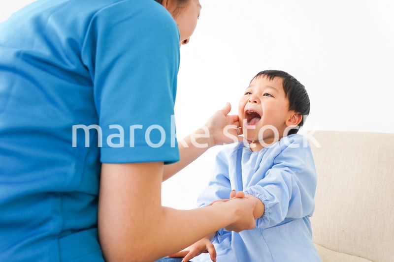 子どもを診察する若い看護師