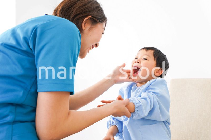 子どもを診察する若い看護師