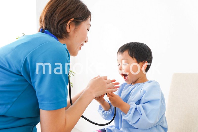 子どもを診察する若い看護師