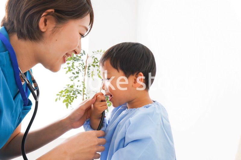 子どもを診察する若い看護師