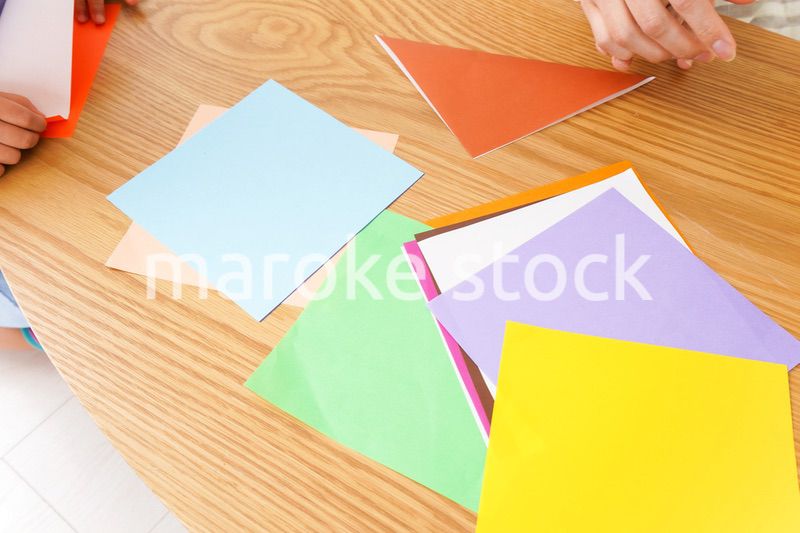 幼稚園で折り紙をする子どもと先生