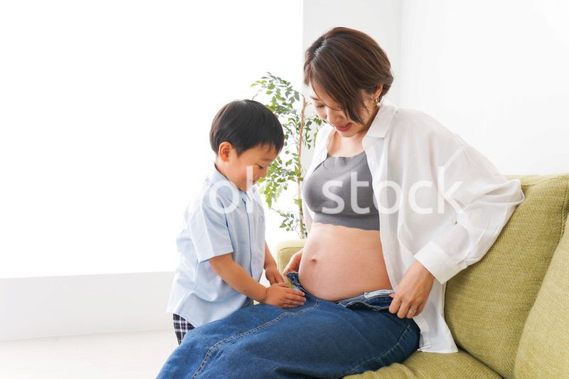 赤ちゃんの鼓動を聞く小さな男の子