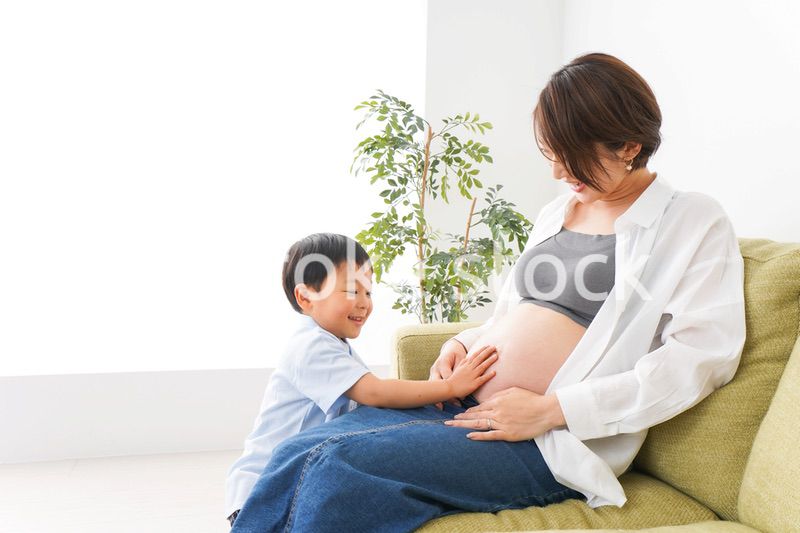 赤ちゃんの鼓動を聞く小さな男の子