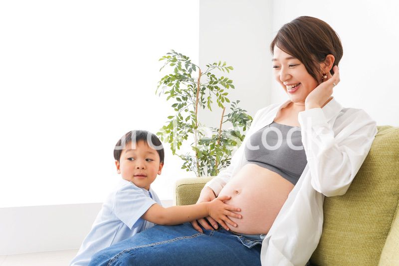 赤ちゃんの鼓動を聞く小さな男の子