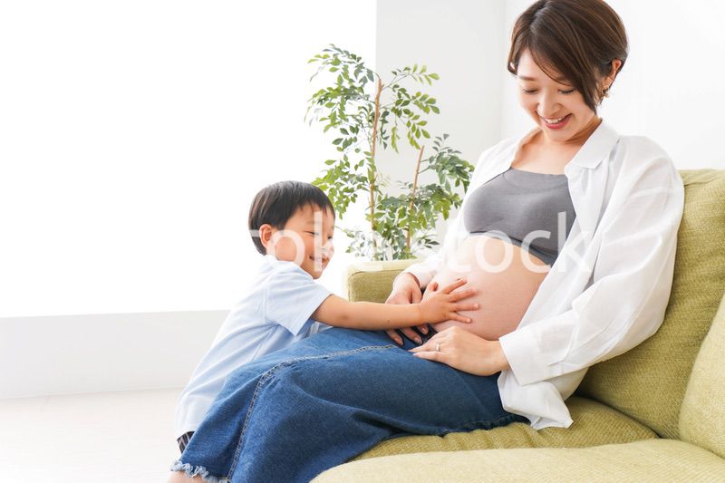 赤ちゃんの鼓動を聞く小さな男の子