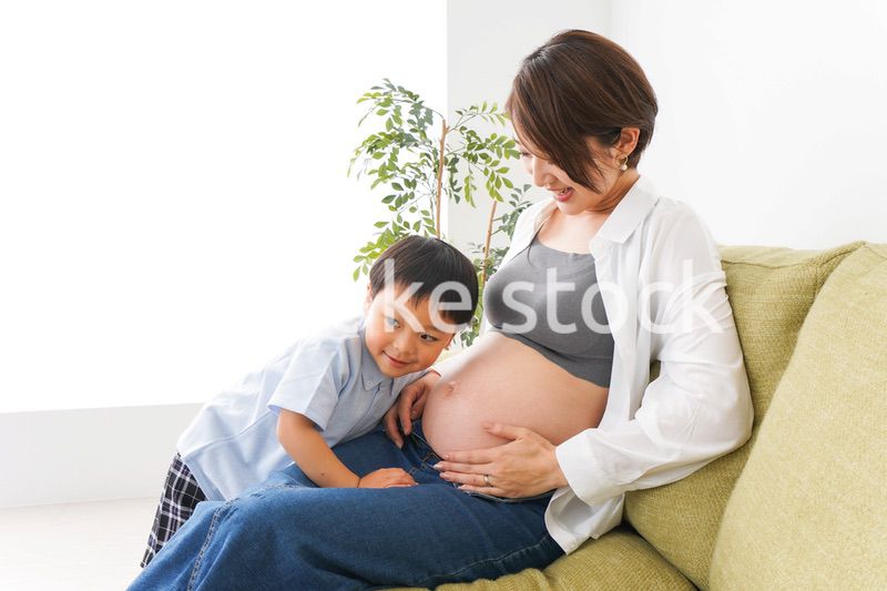赤ちゃんの鼓動を聞く小さな男の子