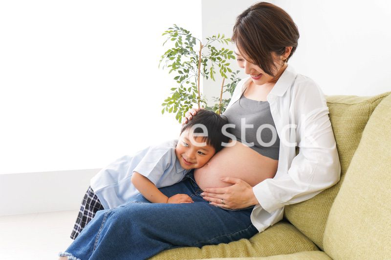 赤ちゃんの鼓動を聞く小さな男の子