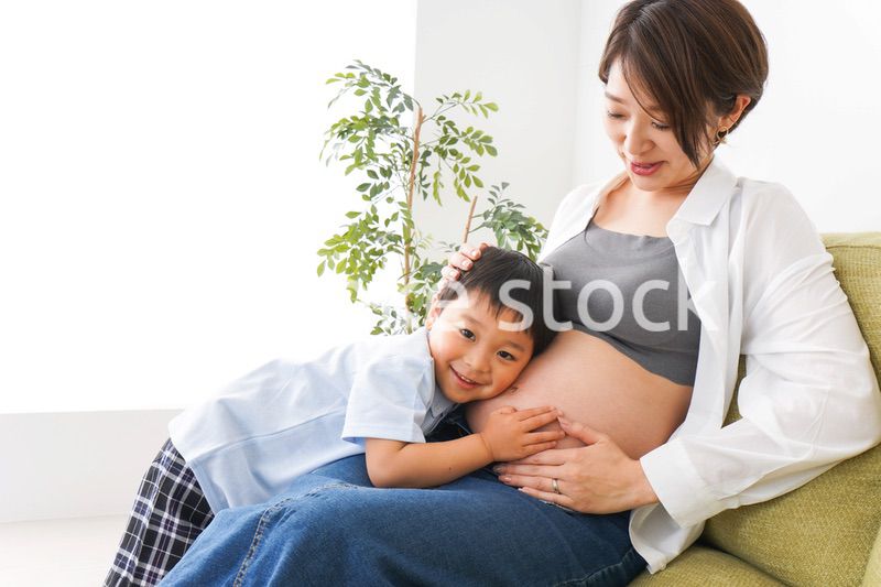 赤ちゃんの鼓動を聞く小さな男の子