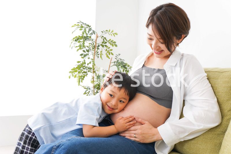 赤ちゃんの鼓動を聞く小さな男の子