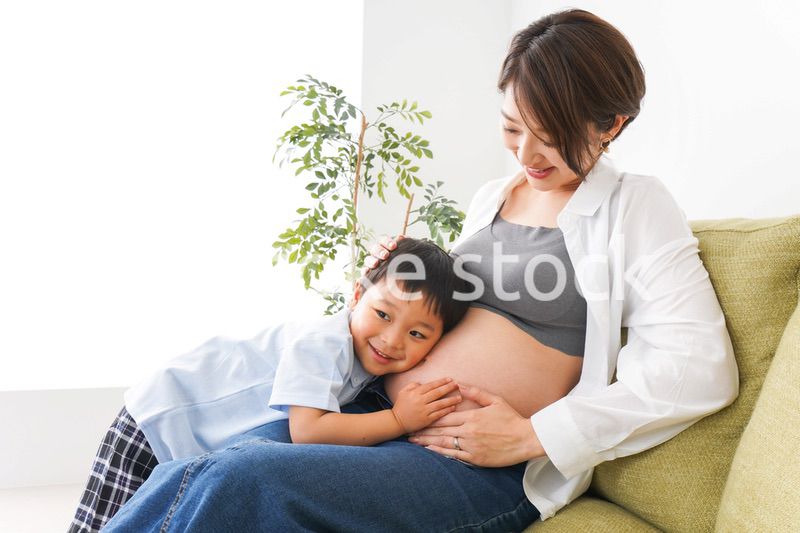 赤ちゃんの鼓動を聞く小さな男の子