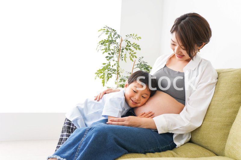 赤ちゃんの鼓動を聞く小さな男の子