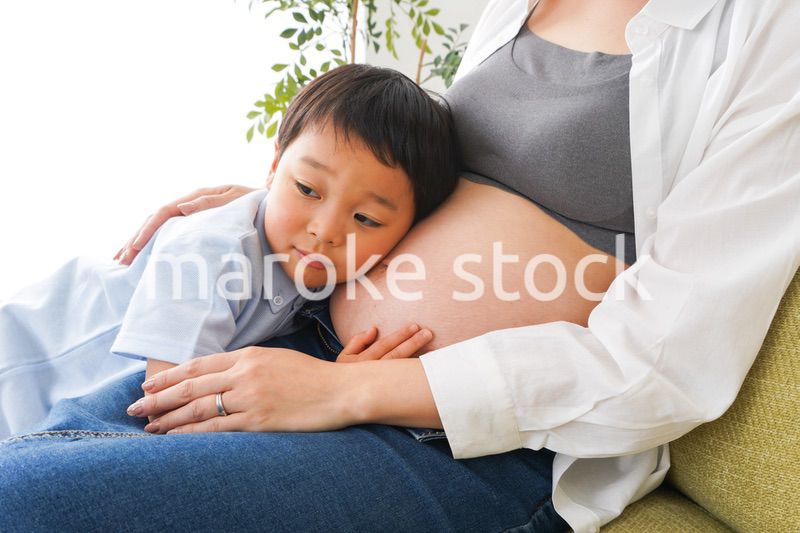 赤ちゃんの鼓動を聞く小さな男の子