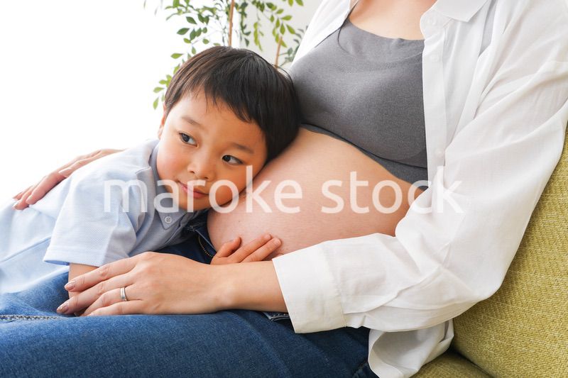 赤ちゃんの鼓動を聞く小さな男の子