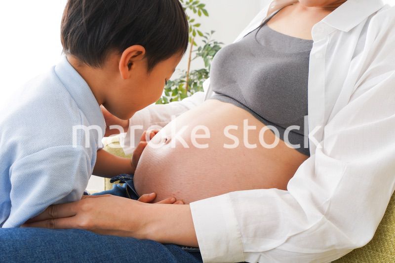 赤ちゃんの鼓動を聞く小さな男の子