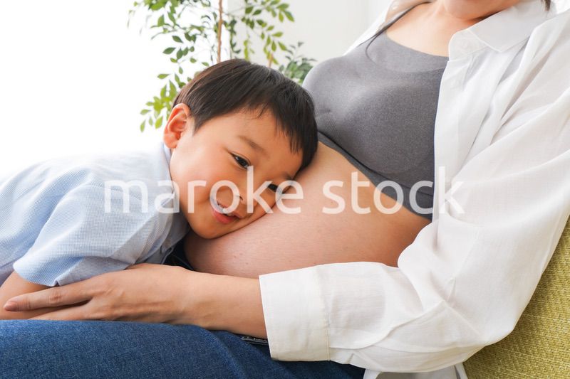 赤ちゃんの鼓動を聞く小さな男の子