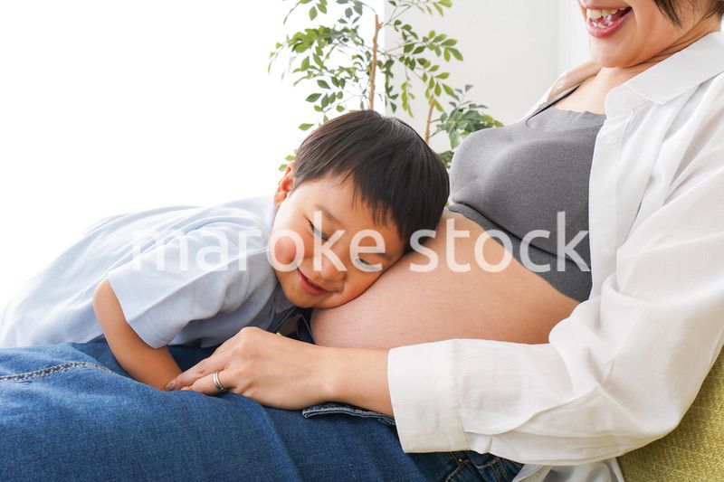 赤ちゃんの鼓動を聞く小さな男の子