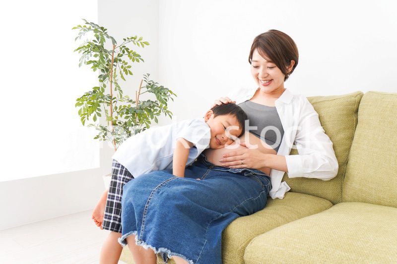 赤ちゃんの鼓動を聞く小さな男の子