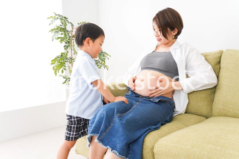 赤ちゃんの鼓動を聞く小さな男の子