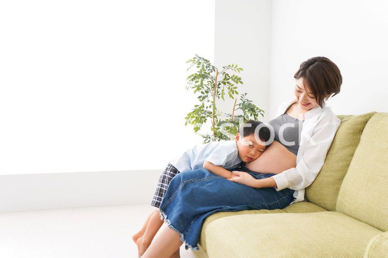 赤ちゃんの鼓動を聞く小さな男の子