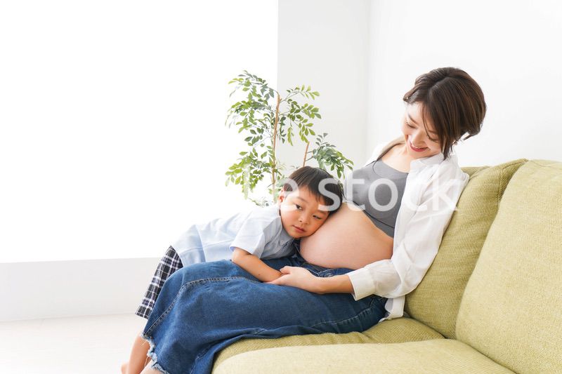 赤ちゃんの鼓動を聞く小さな男の子