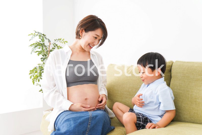 赤ちゃんの鼓動を聞く小さな男の子