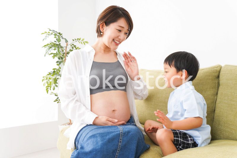 赤ちゃんの鼓動を聞く小さな男の子