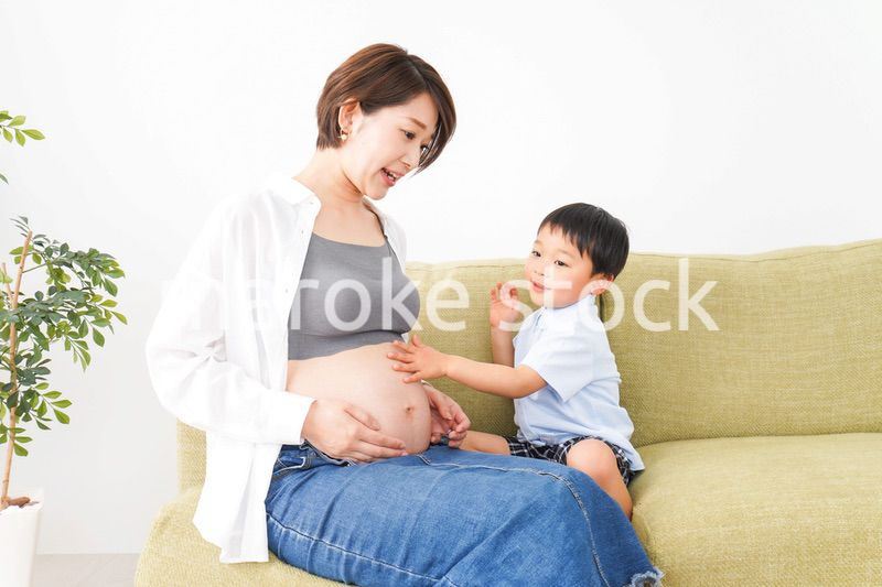 赤ちゃんの鼓動を聞く小さな男の子