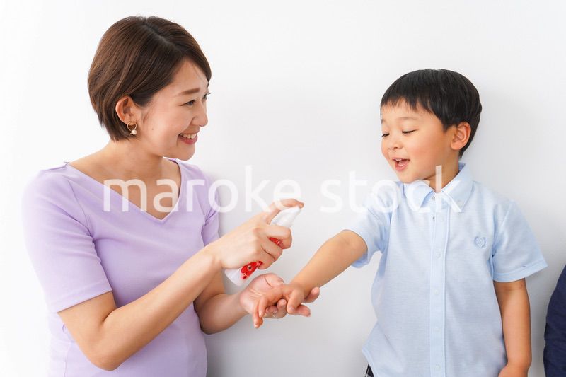 子どもにスプレーをするお母さん
