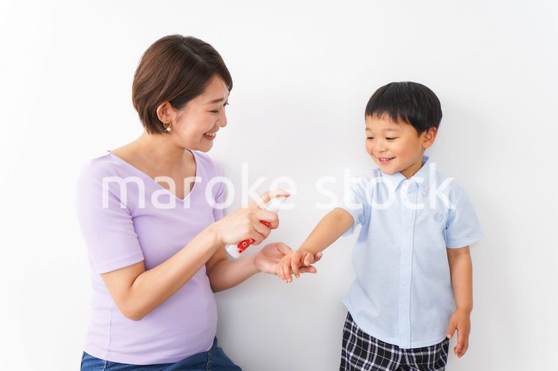 子どもにスプレーをするお母さん