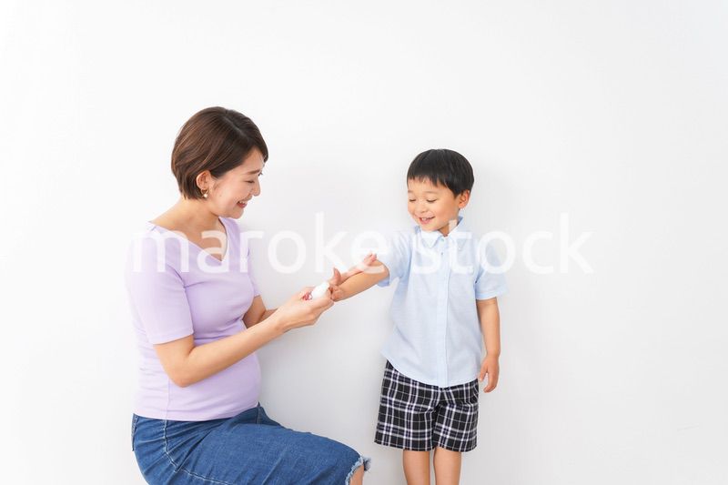 子どもにスプレーをするお母さん