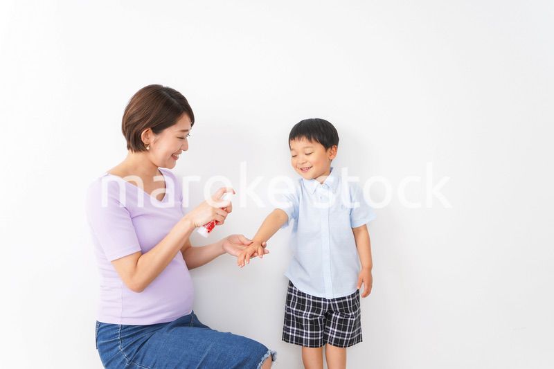 子どもにスプレーをするお母さん