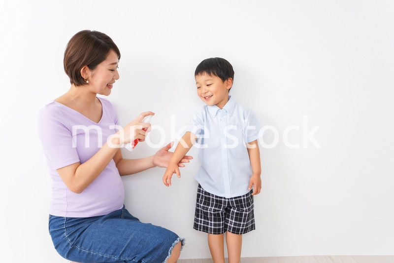子どもにスプレーをするお母さん