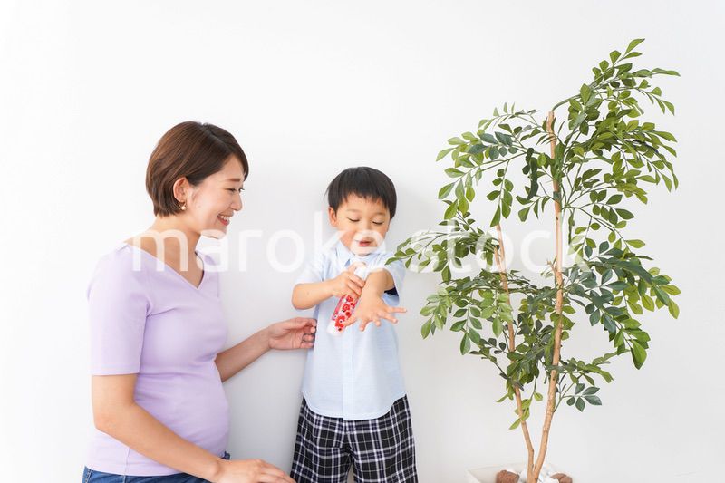 子どもにスプレーをするお母さん