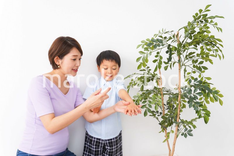 子どもにスプレーをするお母さん