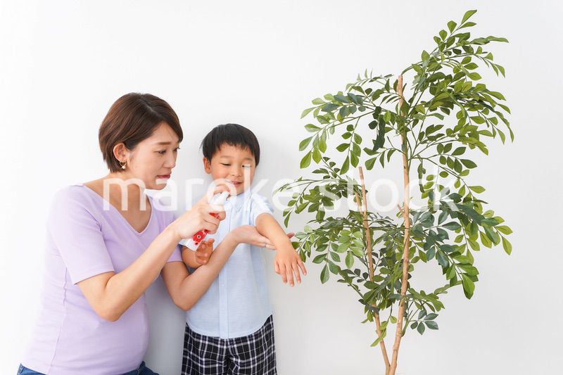 子どもにスプレーをするお母さん