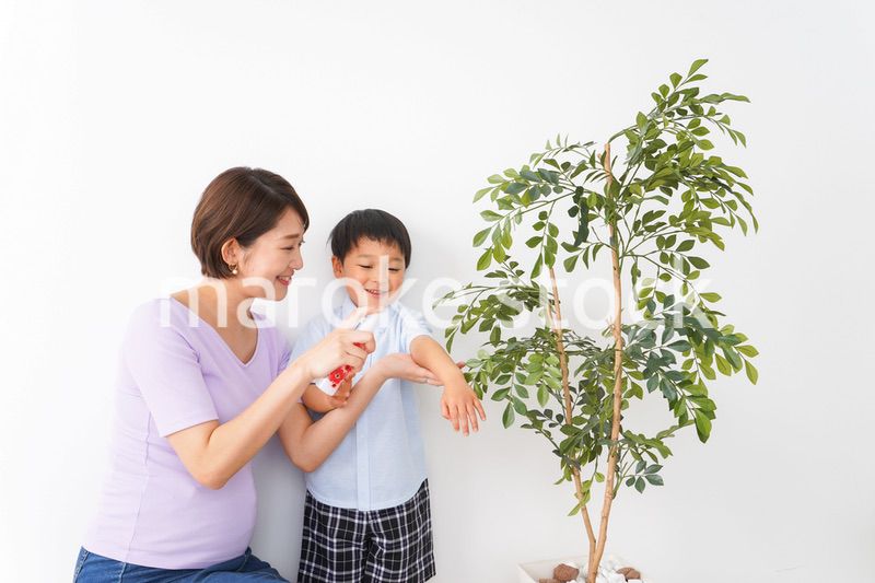 子どもにスプレーをするお母さん